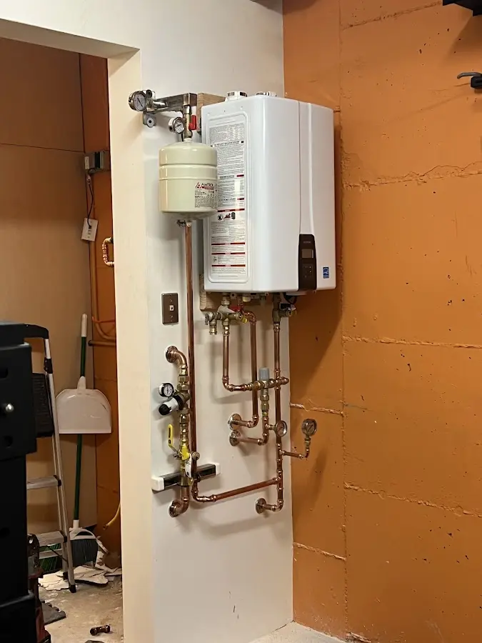 Plumbing technician inspecting water heater connections in Beckley